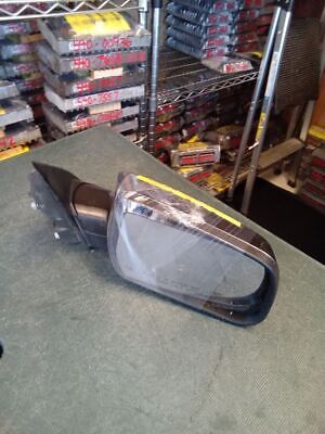 A side view mirror on the ground in front of a store.