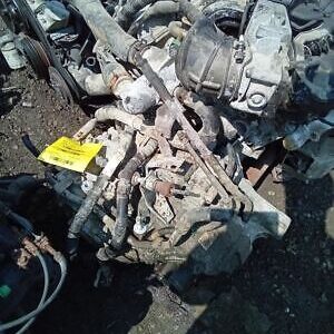 A pile of old engines and parts on the ground.