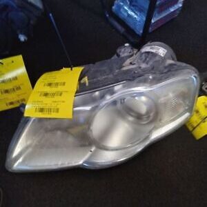 A silver car headlight with yellow tags on it.