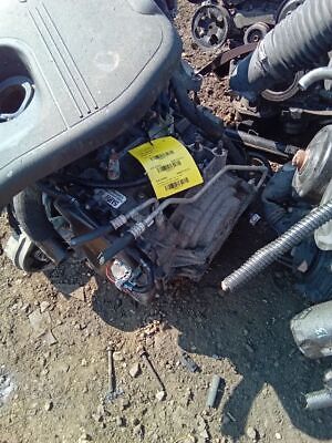 A car engine that is sitting in the dirt.