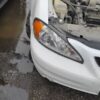 A white car that has been hit by a truck.