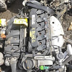 A car engine is shown in the dirt.