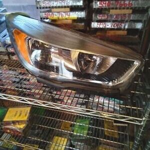 A car headlight sitting on top of a shelf.