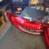 A car is parked in the garage with its lights on.