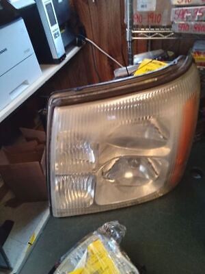 A headlight that is broken and sitting on the floor.