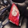 A red and white car tail light on top of black leather chair.