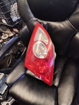 A red and white car tail light on top of black leather chair.