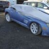 A blue car with some white tarps on it