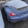 A blue car with the hood up in a parking lot.
