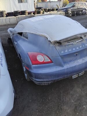 A blue car with the hood up in a parking lot.