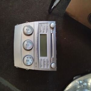 A silver car radio sitting on top of the floor.