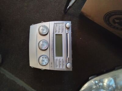 A silver car radio sitting on top of the floor.