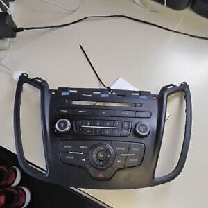 A radio is sitting on the table and has wires plugged in.