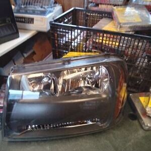 A car headlight sitting on top of the floor.