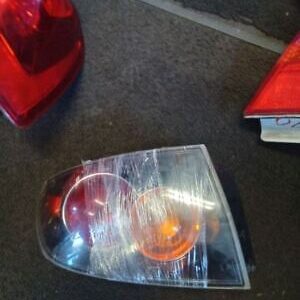 A car 's headlight is broken and sitting on the floor.