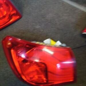 A red car tail light sitting on the floor.