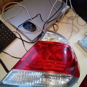 A laptop and a red car light on the table