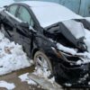 A car that has been smashed in the snow.