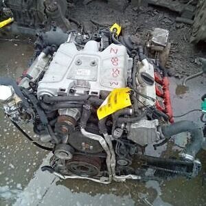 A car engine is being worked on by someone.