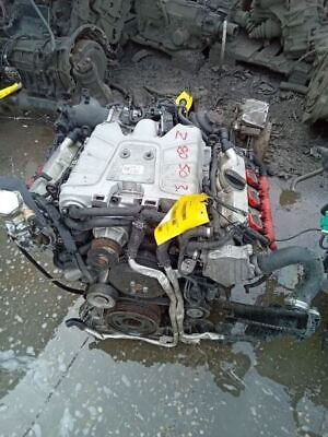 A car engine is being worked on by someone.