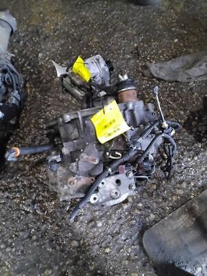 A broken car engine and other parts on the ground.