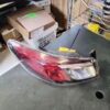A car 's left side headlight is sitting on the floor.