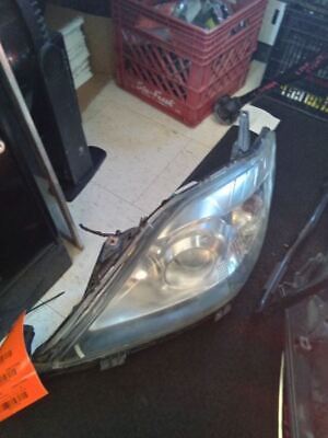 A broken headlight is sitting on the floor.