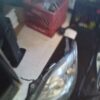 A car 's headlight is broken and sitting on the floor.