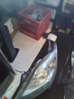 A car 's headlight is broken and sitting on the floor.
