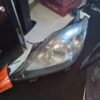 A car headlight that is broken and sitting on the floor.