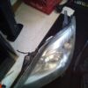 A car headlight with the hood up.