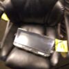 A black leather chair with a clear plastic tray on the back.