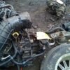 A car engine and other parts on the ground.