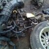 A car engine and other parts on the ground.