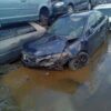 A car that has been wrecked in the water.