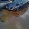 A car that has been wrecked in the mud.