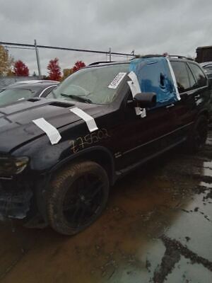 A black suv with some white tape on it's windshield.