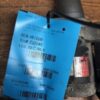 A blue tag is attached to the back of a piece of wood.