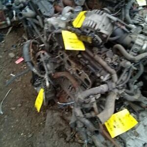 A pile of old engines with yellow tags on them.