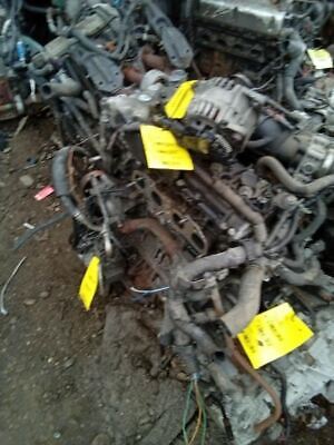 A pile of old engines with yellow tags on them.