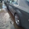 A car parked in the middle of a puddle.