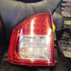 A car 's tail light is on the back of a black leather chair.