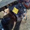 A car engine sitting on the ground with a yellow sticker.