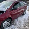 A red car is parked in the snow