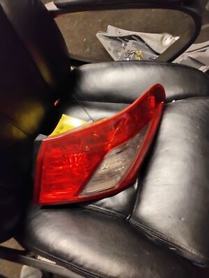 A car 's tail light is on the seat of a black leather chair.
