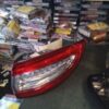A car is parked in front of many stacks of cds.