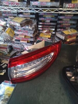 A car is parked in front of many stacks of cds.