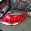 A red and silver car tail light on the road.