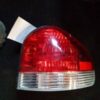 A red and white car tail light on a black surface