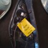 A yellow tag is attached to the side of a car.